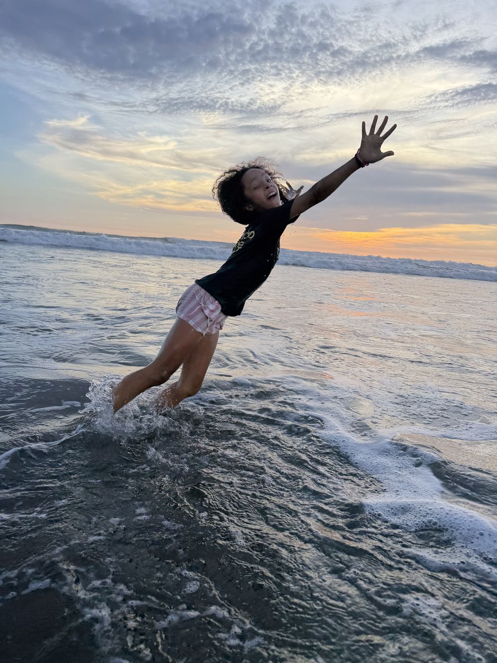 A child leaping through the surf at sunset, Playa Grande