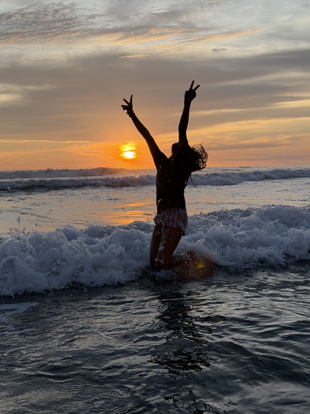A child in the surf at sunset, Playa Grande